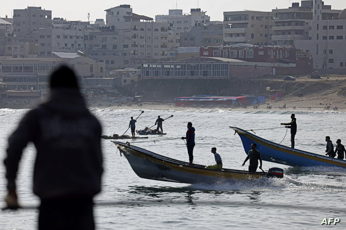 Fishermen ride their boats in Gaza City on May 14, 2023 amid a ceasefire ending five days of deadly fighting between Israel and…