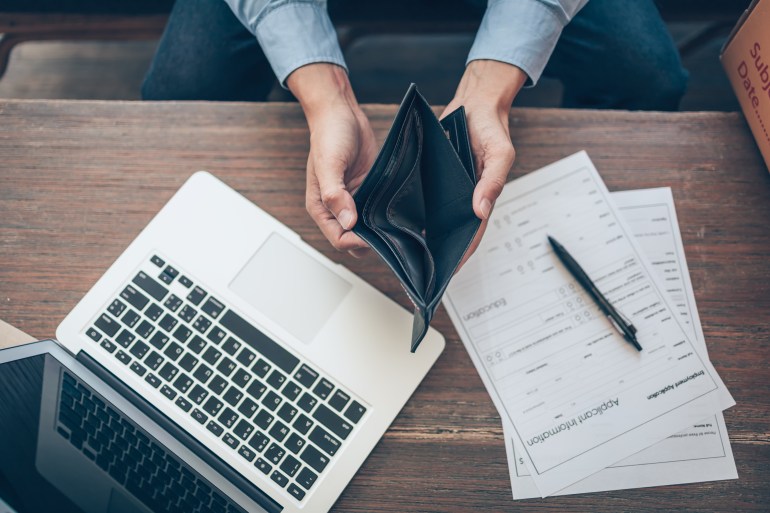 Office worker lost his job and open a wallet without money. Man empty wallet, man broke concept.