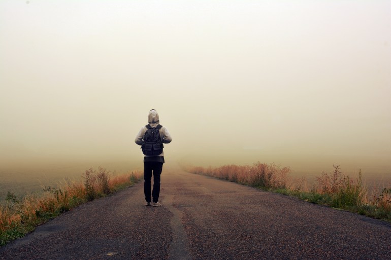 Man on the road in the foggy sunrise; Shutterstock ID 318492530; purchase_order:Creative Team ; job:; client:; other: