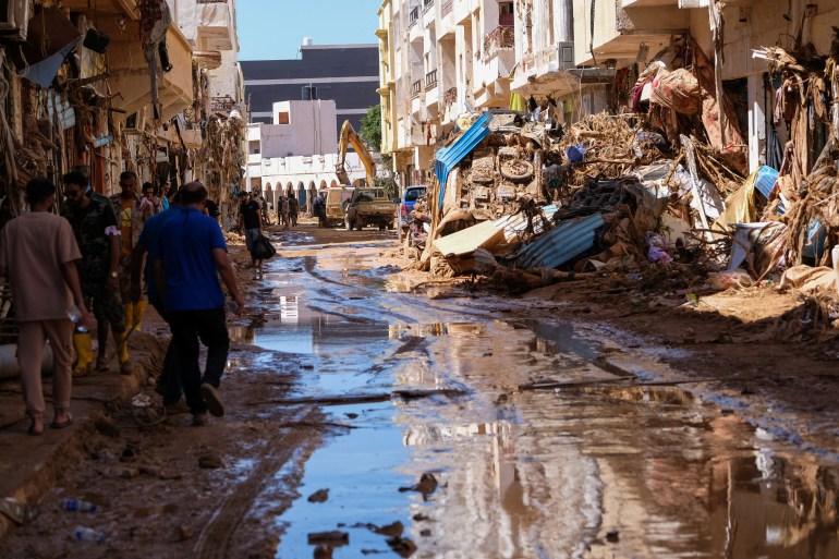 People walk in the mud between the rubbles, after a powerful storm and heavy rainfall hit Libya, in Derna, Libya September 13, 2023. REUTERS/Esam Omran Al-Fetori