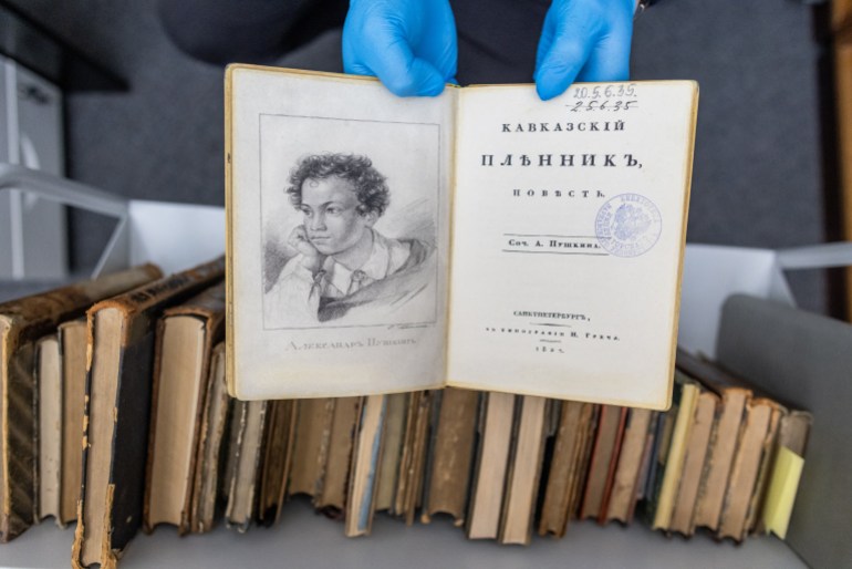 A university employee presents a fake copy of a first edition of the 1822 book 'Kavkazskiy plennik: povest' by Alexander Pushkin at the University of Warsaw library in Warsaw, Poland on November 14, 2023. - A spate of thefts of rare Russian classics worth millions of euros from libraries across Eastern Europe has left a trail that points all the way to Moscow. (Photo by Wojtek Radwanski / AFP)