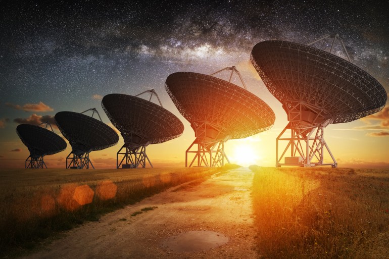 Satellite dish view at night with milky way in the sky