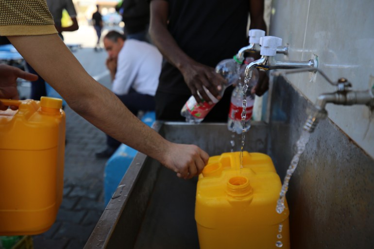 Palestinians fill water in Deir al-Balah, central Gaza Strip on October 15, 2023 . Thousands of Palestinians fled on October 14 to southern Gaza in search of refuge after Israel warned them to evacuate ahead of an expected ground offensive against Hamas in response. The deadliest attack in Israel's history.