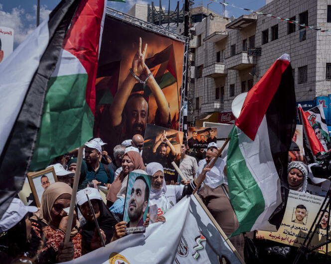 متظاهرون يحملون صور السجناء الفلسطينيين، بمن فيهم مروان البرغوثي، زعيم الانتفاضة الثانية، المسجون منذ عام 2002، خلال المظاهرة التي جمعت عدة مئات من الفلسطينيين في وسط مدينة رام الله لدعم الأسرى الفلسطينيين وسكان غزة.  الضفة الغربية، 3 أغسطس 2024.