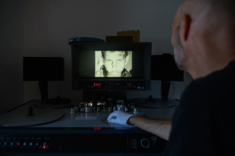 Archivist Matthieu Larroque inspects a reel of film showing scenes of daily life in Palestine, part of a collection of 40 Palestinian films made between 1960 and 1980, at the Conservation and Research Center of the Toulouse Cinematheque in Toulouse, southwestern France, on August 1, 2024. - In the early 1980s, the Palestinian Film Institute in Beirut, where around a hundred militant films were stored, was bombed by Israel during the Lebanon war. Its director, Khadijeh Habashneh, fled the country, leaving the reels behind. Almost 40 years later, the 79-year-old former director of the Institute has managed to collect 40 short and medium-length films, in 16 and 30 mm formats, which will be shown to the general public at the Cine Palestine festival in Toulouse. (Photo by Ed JONES / AFP)