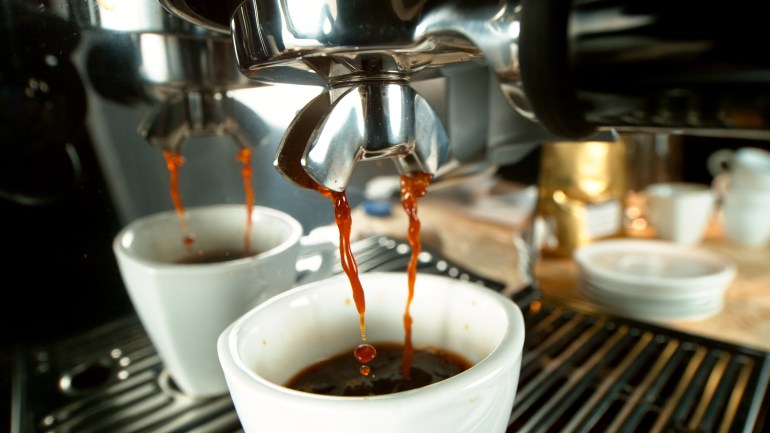 prepares espresso in his coffee shop; close-up