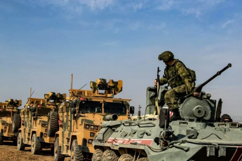 Turkish and Russian military vehicles drive on a joint patrol in the countryside of Darbasiyah town in Syria's northeastern Hasakeh province on the Syrian-Turkish border on November 1, 2019. Turkey started joint patrols with Russia in northern Syria today to verify whether Kurdish forces have withdrawn from a key border zone in compliance with a deal reached between the two governments. (Photo by Delil SOULEIMAN / AFP) (Photo by DELIL SOULEIMAN/AFP via Getty Images)