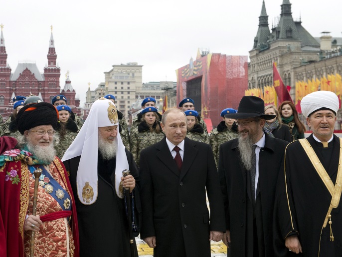 (L-R) Head bishop of the Russian Union of Evangelical Christian Faith Sergei Ryakhovsky, head of the Traditional Buddhist Sangha of Russia Pandido Khambo Lama Damba Ayusheev, Supreme Mufti of Russia Talgat Tadzhuddin, Patriarch of Moscow and all Russia Kirill, Russian President Vladimir Putin, Chief Rabbi of Russia Berel Lazar and Russia's Chief of Mufti Council Rawil Gaynetdin pose for a photo during a flower-laying ceremony on National Unity Day in Red Square in Mosc