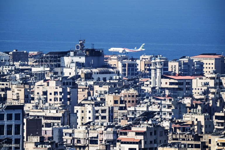 A Middle East Airlines commercial aircraft flies near Beirut's southern suburbs as it approaches the airport runway on August 9, 2024. Many in Beirut's southern suburbs, a packed residential area known as Dahiyeh which is also a Hezbollah bastion, have been trying to leave, fearing full-blown war between the Iran-backed group and Israel in the wake of the commander's killing. (Photo by JOSEPH EID / AFP) (Photo by JOSEPH EID/AFP via Getty Images)