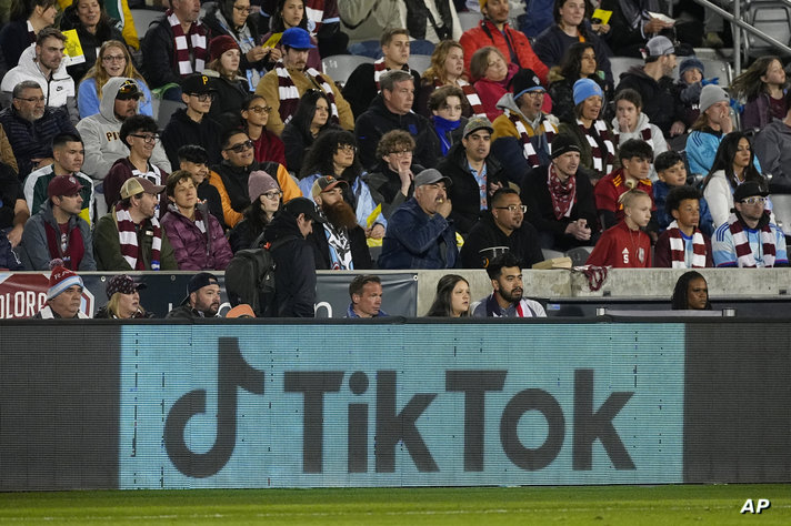 An electronic sign adveertising the social media platform Tik Tok is illuminated on a board along the pitch in the first half…