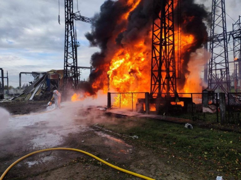 Firefighters work to put out a fire at energy infrastructure facilities, damaged by a Russian missile strike