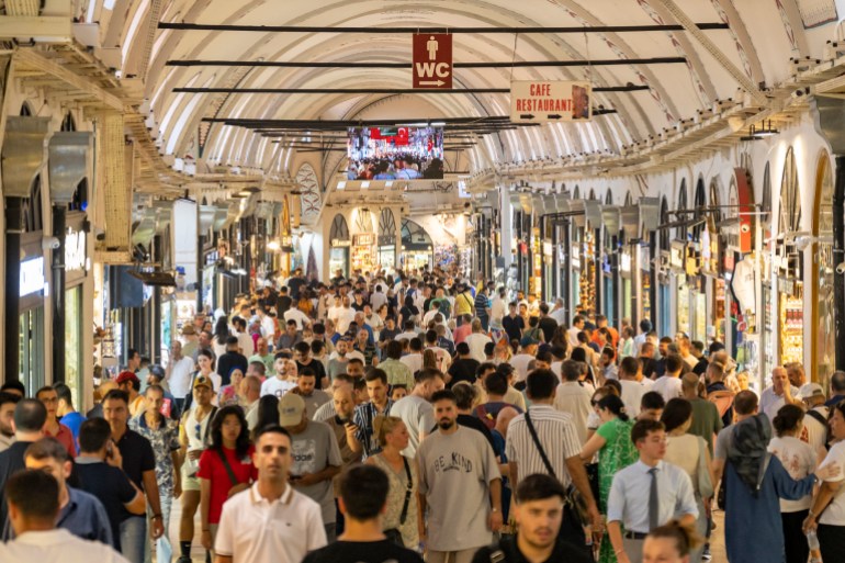 Visitors walk at the historical Grand Bazaar in Istanbul on July 9, 2024. - Cut-price branded perfumes and fake designer handbags line the alleys of Istanbul's venerable Grand Bazaar, flooded by luxury imitations, with its traditional artisans saying they are putting their livelihoods at risk. (Photo by Yasin AKGUL / AFP)