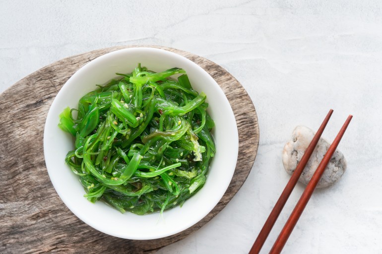 Wakame seaweed salad with sesame seed. Traditional Japanese food. Top view. ; Shutterstock ID 1005726052; purchase_order: AJ; job: ; client: ; other: