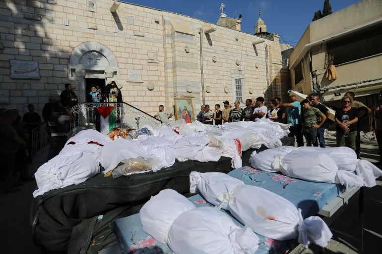 Relatives attend the funeral of Palestinians who were killed in Israeli air strikes that hit part of Saint Porphyrius Church, which was housing displaced Palestinians in Gaza City, in October 2023 [Abed Khaled/AP]