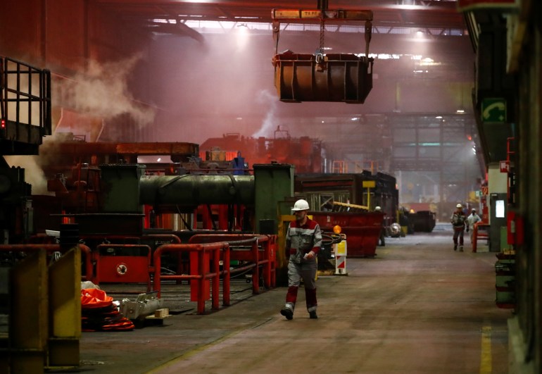 Steel workers of ThyssenKrupp walk through the hall of the rolling mill of its steel factory in Duisburg, Germany, January 30, 2020. REUTERS/Wolfgang Rattay