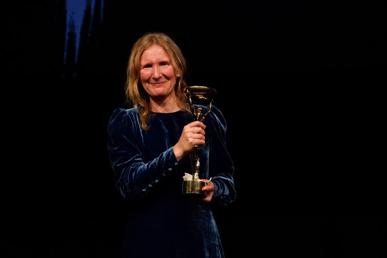 Samantha Harvey poses with the trophy after winning the Booker Prize award 2024, in London, Tuesday, Nov. 12, 2024. (AP Photo/Alberto Pezzali)