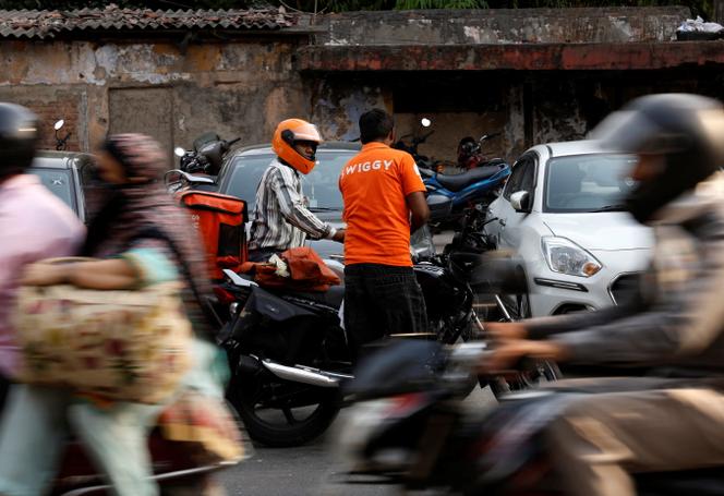 موظفو شركة Swiggy، في أحد أسواق نيودلهي (الهند)، 6 مايو 2024.