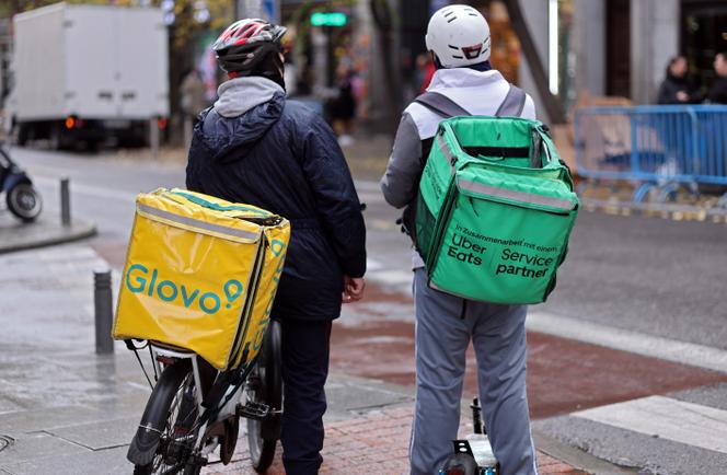 رجال توصيل يعملون في شركتي Glovo وUber Eats، في مدريد، 2 ديسمبر 2024.