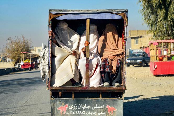 نساء أفغانيات يرتدين البرقع يتم نقلهن في الجزء الخلفي من السيارة، في قندهار، أفغانستان، 29 ديسمبر 2024.