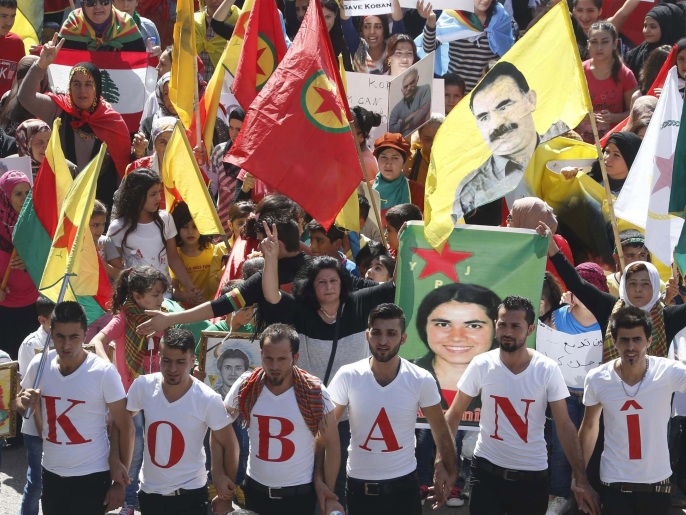 Kurdish protesters wear shirts forming the word 'Kobani' as others wave Lebanese and Kurdish flags and carry the image of Abdullah Ocalan, jailed leader of the Kurdistan Workers' Party (PKK), during a demonstration against Islamic State (IS) insurgent attacks on the Syrian Kurdish town of Kobani, in Beirut in this October 12, 2014 file photo. As southeast Turkey's Kurds rioted last week in fury at Ankara's refusal to rescue the Syrian Kurdish town of Kobani from advancing Islamists, it was to Ocalan that Prime Minister Ahmet Davutoglu turned for help. Sitting in jail on the windswept island where he has spent the last 15 years, Ocalan wields more power as a peacemaker than he ever did as the guerrilla commander leading a Kurdish insurgency in which 40,000 people have died. To match story TURKEY-KURDS/OCALAN. REUTERS/Mohamed Azakir/Files (LEBANON - Tags: POLITICS CIVIL UNREST)