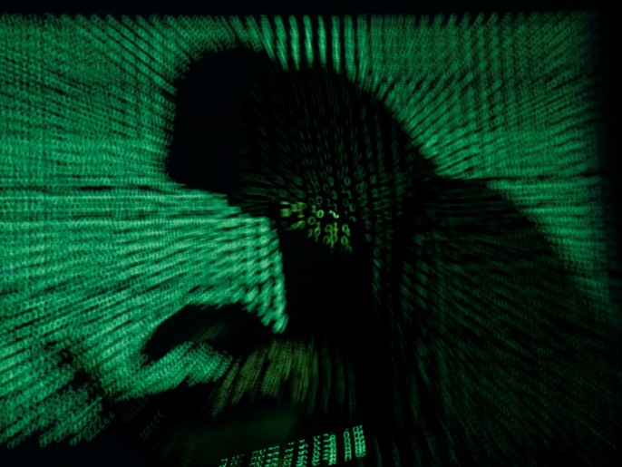 A hooded man holds a laptop computer as cyber code is projected on him in this illustration picture taken on May 13, 2017. Capitalizing on spying tools believed to have been developed by the U.S. National Security Agency, hackers staged a cyber assault with a self-spreading malware that has infected tens of thousands of computers in nearly 100 countries. REUTERS/Kacper Pempel/Illustration TPX IMAGES OF THE DAY