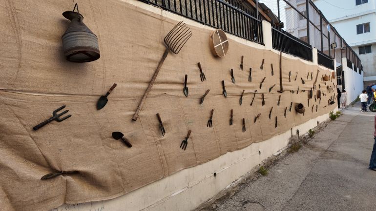 معدات حرفية تراثية تزين حائط السوق الشعبي والتراثي في بلدة كفررمان (الجزيرة)