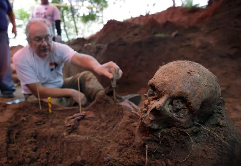 A member of Paraguay’s Truth and Justice Commission examines skeletal remains found at the National Police Special Forces headquarters in Asuncion, Paraguay, on Tuesday, March 19, 2013. This was the 14th skeleton found at the location which was used as a clandestine prison during the military dictatorship of General Alfredo Stroessner [Jorge Saenz/AP]