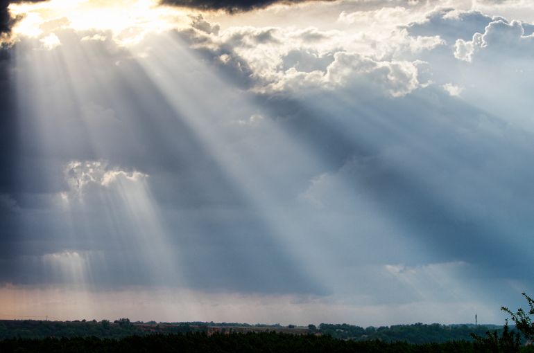 Rays of sunshine breaking through the clouds after a storm.
