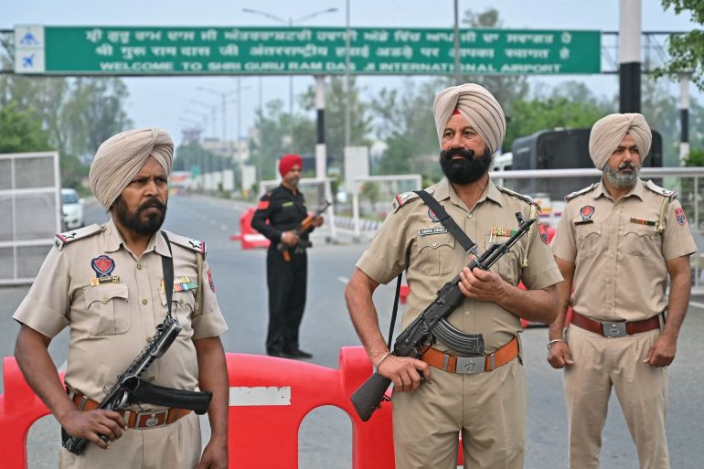 Policemen stand guard on the entrance road of the Shri Guru Ram Das Ji International Airport on the outskirts of Amritsar on May 7, 2025.
