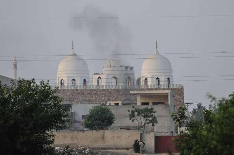 Local residents stand outside a mosque of an Islamic seminary partially damaged by a suspected Indian missile attack, outskirts of Bahawalpur, Pakistan, Wednesday, May 7, 2025. (AP Photo/Asim Tanveer)