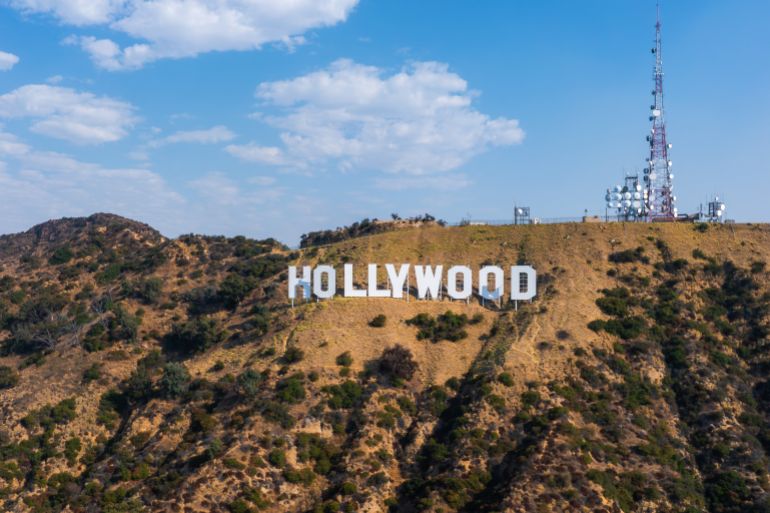 Los Angeles, USA. July 20, 2024. The Hollywood Sign stands on Mount Lee in Los Angeles, California, surrounded by rugged terrain and sparse vegetation under a clear blue sky.; Shutterstock ID 2526925291; purchase_order: aljazeera ; job: ; client: ; other: