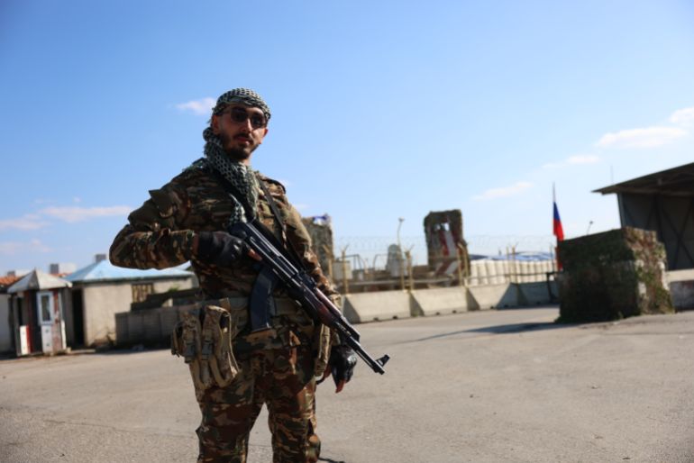 جندي من الجيش السوري أمام القاعدة(الجزيرة)