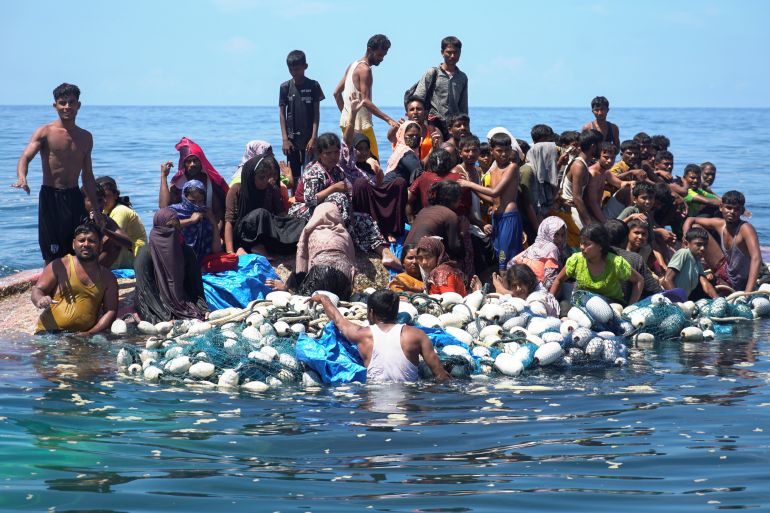 Rohingya refugees stand on a capsized boat before being rescued in the waters of West Aceh, Indonesia, March 21, 2024. REUTERS/Hendri