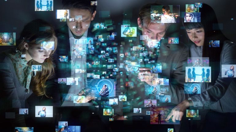 A group of people looking at many pictures.