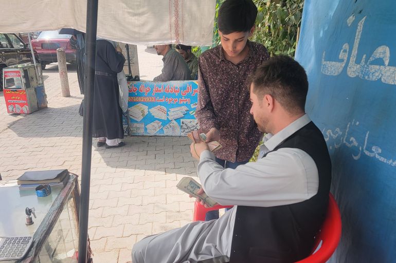 صرّاف أفغاني يتعامل مع أحد العملاء في أحد أسواق كابل حركة يومية تعكس اعتماد المواطنين المتزايد على الصرافة التقليدية وسط أزمة ثقة بالبنوك