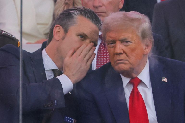 FILE PHOTO: U.S. Secretary of Defense Pete Hegseth talks to U.S. President Donald Trump during the U.S. Army's 250th Birthday parade, on the same day of U.S. President Donald Trump 79th birthday, in Washington, D.C., U.S., June 14, 2025. REUTERS/Carlos Barria/File Photo