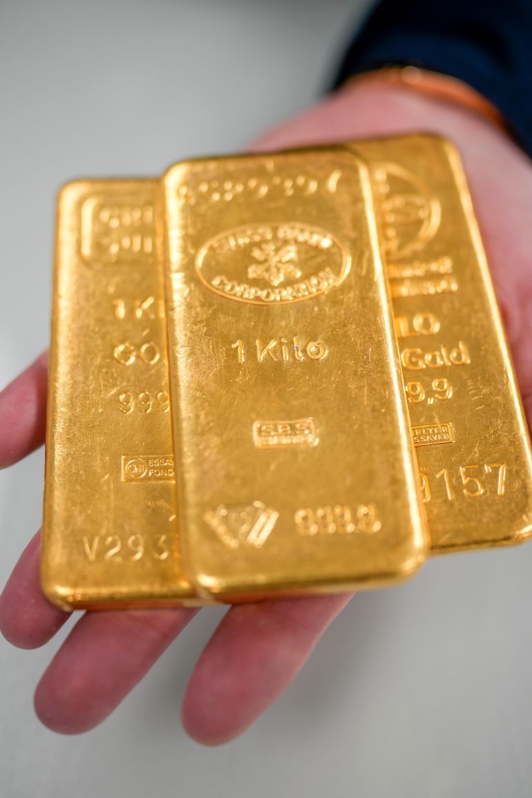 BIRMINGHAM, ENGLAND - DECEMBER 13: A jewellery quarter gold dealer poses with three 1kg gold bullion bars on December 13, 2023 in Birmingham, England. Gold prices have increased since the Ukraine War but have soared to record highs since the start of the Hamas-Israel war. Other factors are the weakening US dollar and expected rate cuts from the Federal Reserve. (Photo by Christopher Furlong/Getty Images)