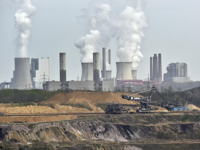 FILE - In this April 3, 2014 file photo giant machines dig for brown coal at the open-cast mining Garzweiler in front of a smoking power plant near the city of Grevenbroich in western Germany. The U.N.’s expert panel on climate change is preparing a new report this weekend outlining the cuts in greenhouse gases, mainly CO2 from the burning of fossil fuels, required in coming decades to keep global warming in check. (AP Photo/Martin Meissner, File)