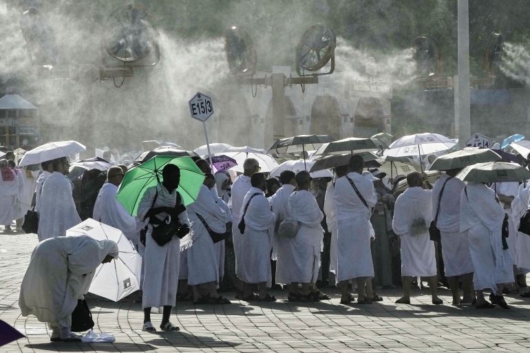 Cooling fans spray water over Muslim pilgrims gathered atop the rocky hill known as the Mountain of Mercy, on the Plain of Arafat, during the annual Hajj pilgrimage near the holy city of Mecca, Saudi Arabia, Thursday, June 5, 2025. (AP Photo/Amr Nabil)