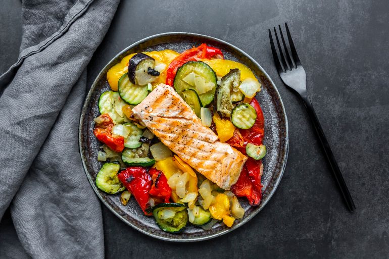 Roasted salmon with vegetables - stock photo