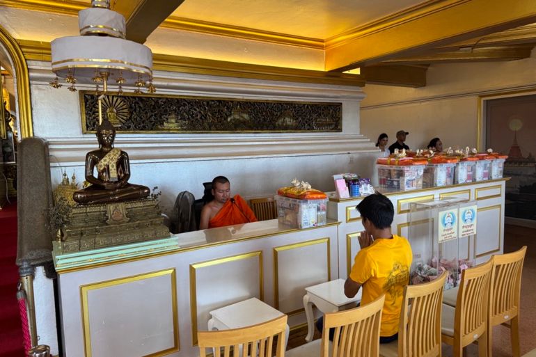 راهب يجلس في مدخل معبد الجبل الذهبي في بانكوك عاصمة تايلند / تصوير أنس زكي - الجزيرة نت