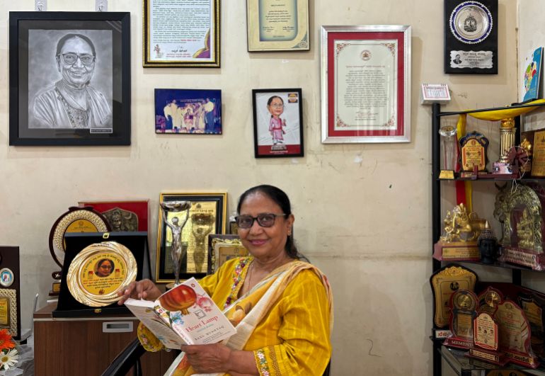 This photograph taken on May 31, 2025 shows Indian lawyer, activist and now International Booker Prize winner Banu Mushtaq posing with the book 'Heart Lamp' at her residence in Hassan, in India's Karnataka state.