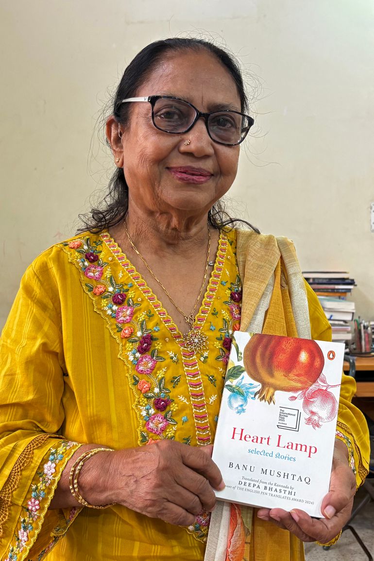 This photograph taken on May 31, 2025 shows Indian lawyer, activist and now International Booker Prize winner Banu Mushtaq posing with the book 'Heart Lamp' at her residence in Hassan, in India's Karnataka state.