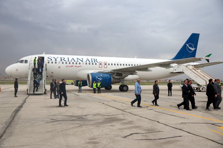 Passengers disembark from a Syrian Air passenger jet, the first aircraft to land at Aleppo airport after it was shut during the offensive that toppled president Bashar al-Assad, after arriving from Damascus on March 18, 2025