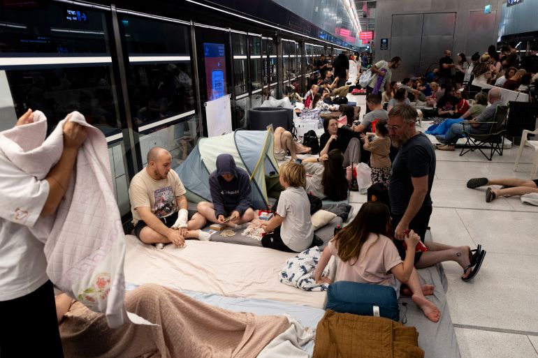 RAMAT GAN, ISRAEL - JUNE 18: People take cover in an underground train station transformed into a public shelter following reports of an incoming missile fired from Iran, on June 18, 2025 in Ramat Gan, Israel. Iran launched a retaliatory missile strike on Israel starting late on June 13, after a series of Israeli airstrikes earlier in the day targeted Iranian military and nuclear sites, as well as top military officials. (Photo by Amir Levy/Getty Images)