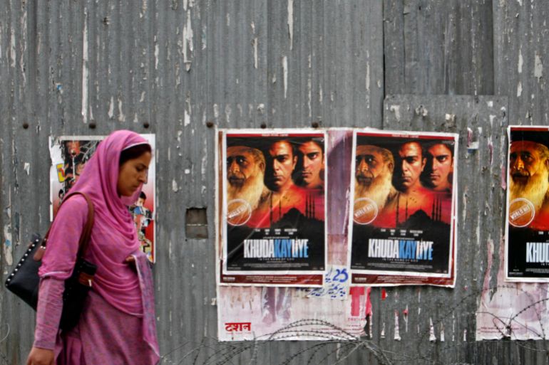 A Kashmiri woman walks past posters of Pakistani movie "Khuda Kay Liye" ("In the Name of God") outside Neelam Cinema, Kashmir's only cinema in Srinagar, June 9, 2008. The first Pakistani movie to get an official screening in Indian Kashmir in over four decades has drawn only a handful of viewers in the Valley's lone cinema, a highly guarded theatre most residents avoid out of fear. "Khuda Kay Liye" ("In The Name of God"), a film about the rift between radical and liberal views of Islam, found few takers in Srinagar, Kashmir's summer capital. A little more than a dozen turned up for the first screening on June 6. REUTERS/Fayaz Kabli (INDIAN-ADMINISTERED KASHMIR)