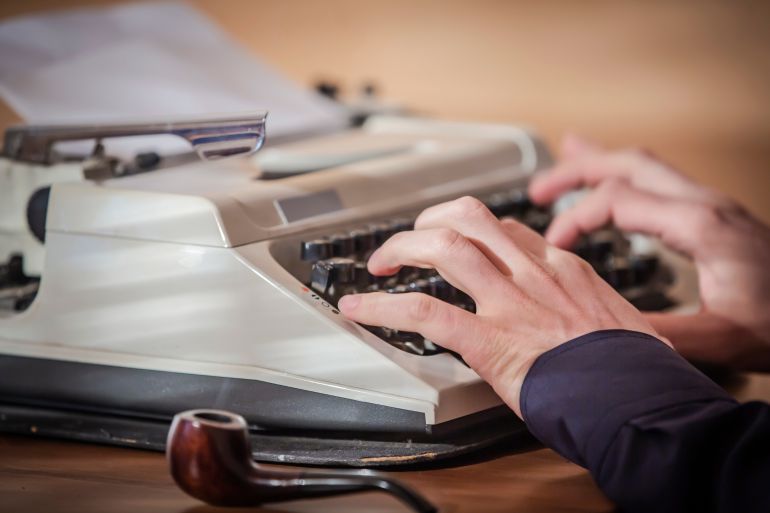 A person typing on a typewriter.