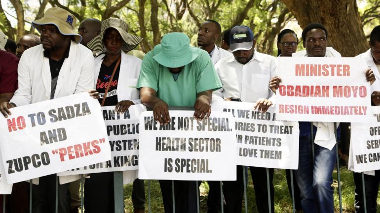 Zimbabwe's senior doctors hold placards during a protest in Harare, Zimbabwe, 04 December 2019. According to reports, doctors handed over a petition to the Speaker of Parliament with a list of demands before they stop their strike. Zimbabwe's doctors have been on strike for more than three months over salary increase and better working conditions. EPA-EFE/AARON UFUMELI