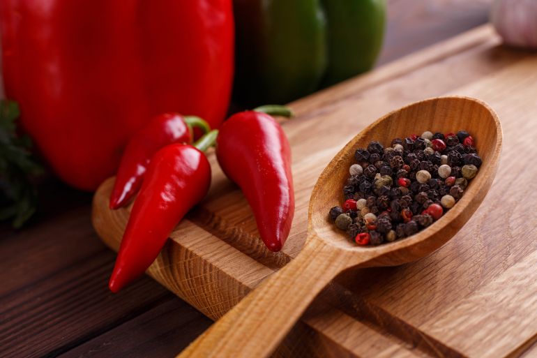 Mixed dried peppers in a wooden spoon, chili peppers, bell peppers. Spices, ingredients, food concept.