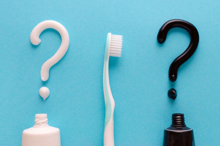 question from white and black toothpaste, teeth care concept, toothbrush on blue background
